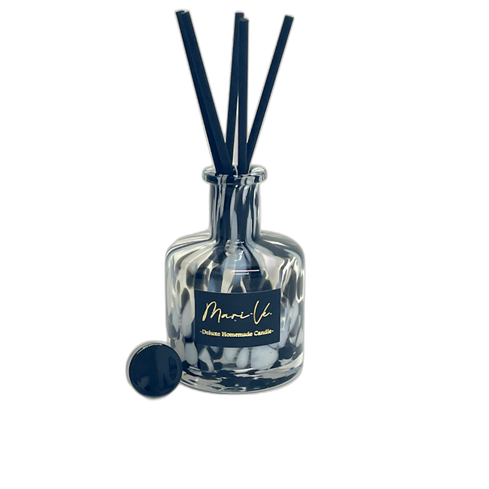 Mari-Ve geurdiffuser in zwart wit print glas met zwarte stokjes en losse dop – luxe huisparfum op transparante achtergrond
