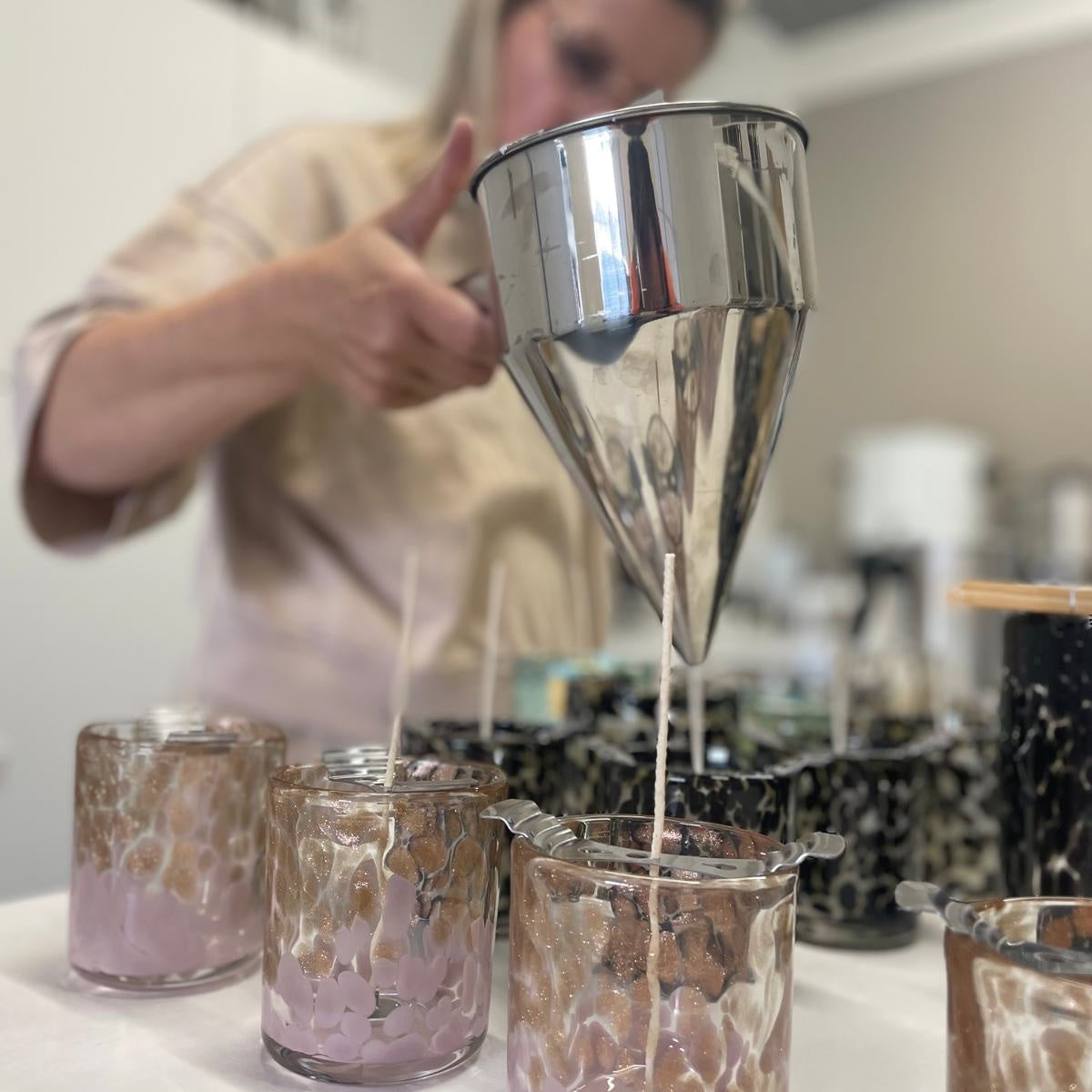Handgieten van Mari-Ve geurkaarsen in luxe mondgeblazen glazen houders met lila accenten – ambachtelijk proces in atelier