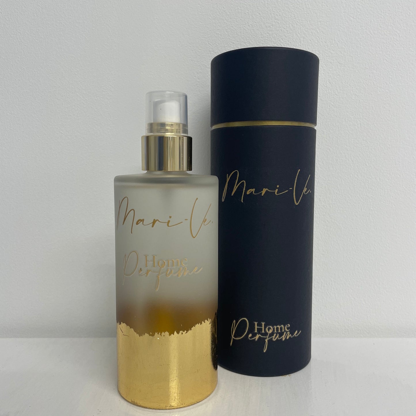 Mari-Ve - Zwarte koker met gouden opdruk logo en home perfume met melkglazen roomspray fles met gouden opdruk logo en home perfume