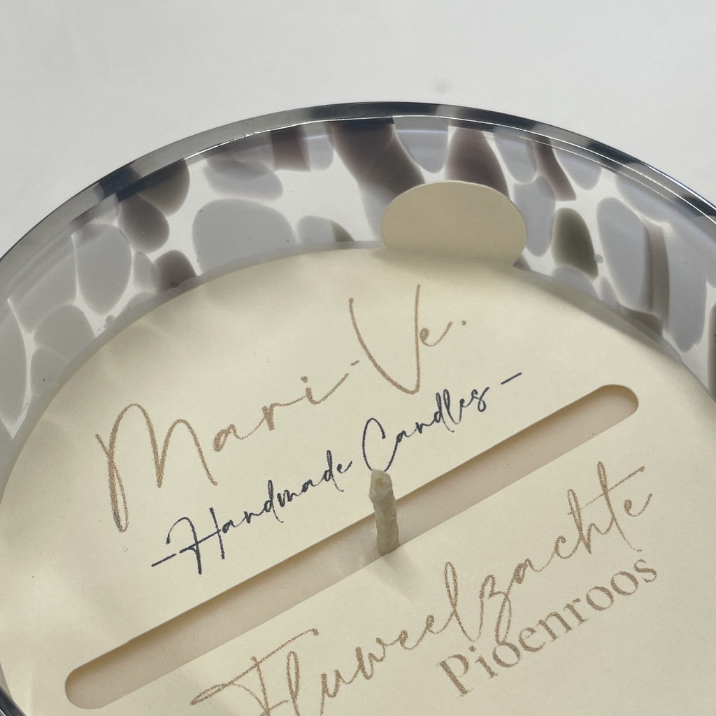 Detail van Mari-Ve’s kaarsstofdoek met handgeschreven logo en geurvermelding Fluweelzachte pioenroos – met handig lipje om het doekje makkelijk met de vingers te verwijderen in gevlekte houder