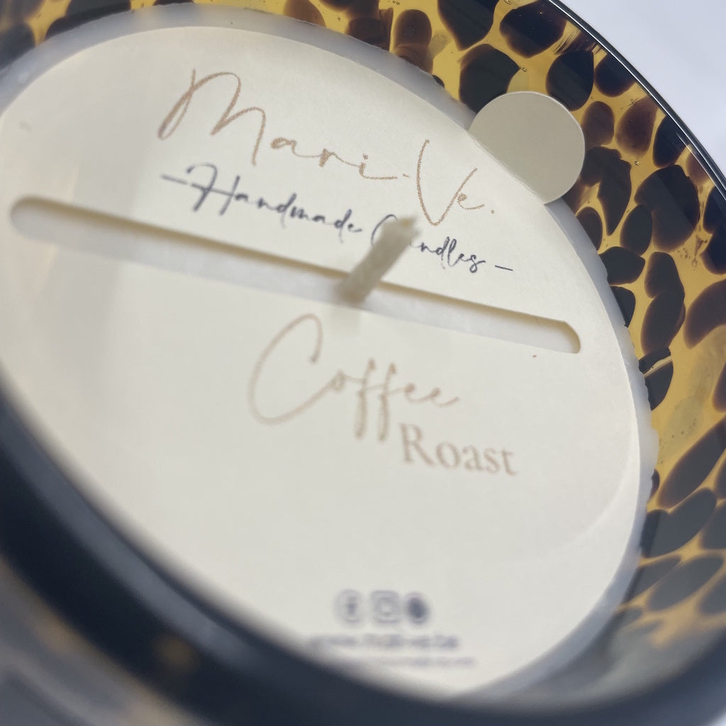 Detail van Mari-Ve’s kaarsstofdoek met handgeschreven logo en geurvermelding Coffee Roast – met handig lipje om het doekje makkelijk met de vingers te verwijderen in gevlekte tijgerprint kaarshouder